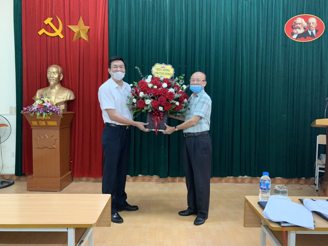 Tổng Giám đốc Tạ Thiên Long (bên trái) tặng hoa chúc mừng Chủ tịch HĐQT Trần Quốc Thấn